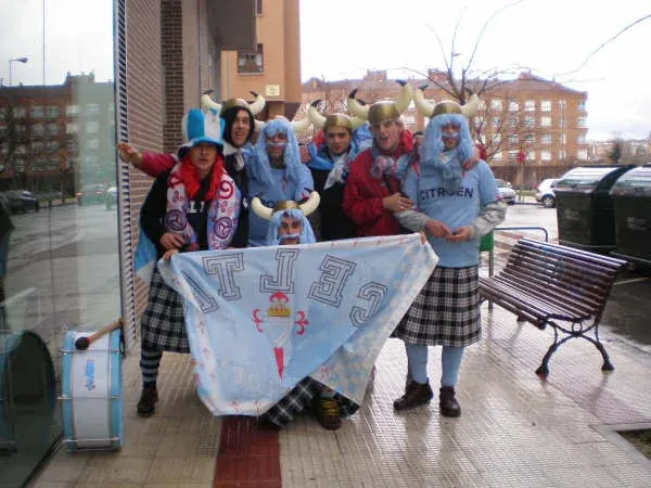 Integrantes da peña con cornos de vikingo, perrucas azuis e a bandeira do Celta en Pamplona